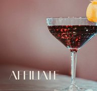 Glas mit ECKES Affiliate Cocktail, garniert mit einer Orangenscheibe