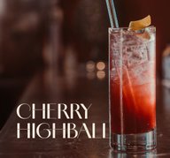 Glas mit ECKES Cherry Highball Cocktail auf Eis, garniert mit einer Orangenzeste und einem Strohhalm