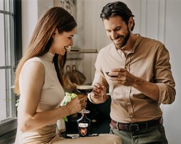 Ein lächelndes Paar in einer Küche, das gemeinsam ECKES Espresso Martini Cocktails genießt.