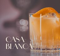 Glas mit ECKES Casablanca Cocktail auf Eis, garniert mit einer Orangenschale