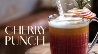 Glas mit ECKES Cherry Punch, garniert mit Apfelscheiben und einem Strohhalm