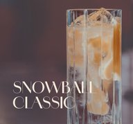 Glas mit ECKES Snowball Classic Cocktail auf Eis, garniert mit einer Zitronenzeste